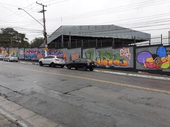Grafiteiros coloriram o muro de uma escola em frente à praça
